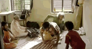 a group of people are sitting on the floor in a room playing instruments .