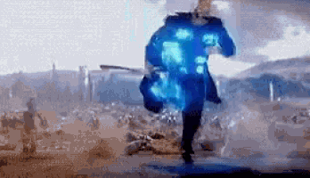 a man is running through a field with a blue light coming out of his jacket .