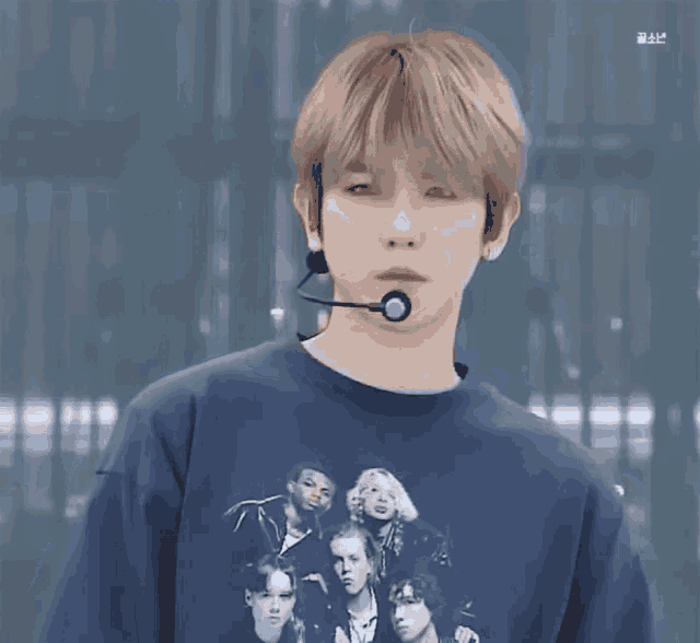 a young man wearing a microphone and a t-shirt with a picture of a group of people .