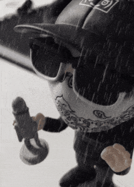 a black and white toy with a bandana and sunglasses is holding a microphone