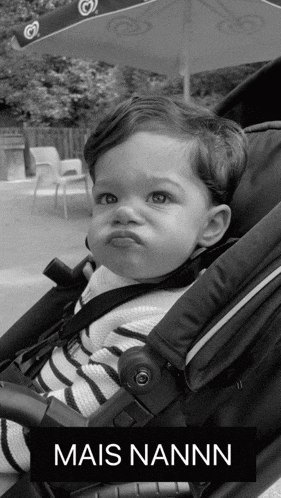 a black and white photo of a baby in a stroller that says mais nann on it