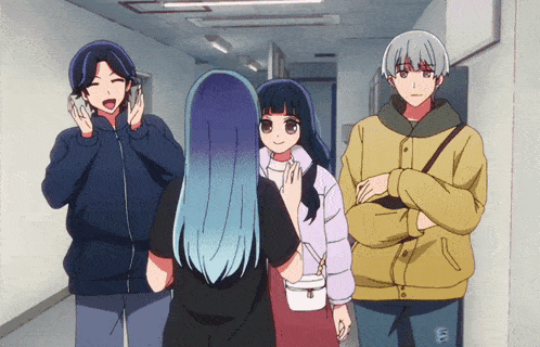 a group of people are standing in a hallway and one of them is wearing a yellow jacket