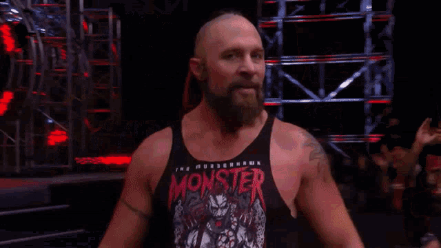 a man with a beard wearing a tank top that says monster