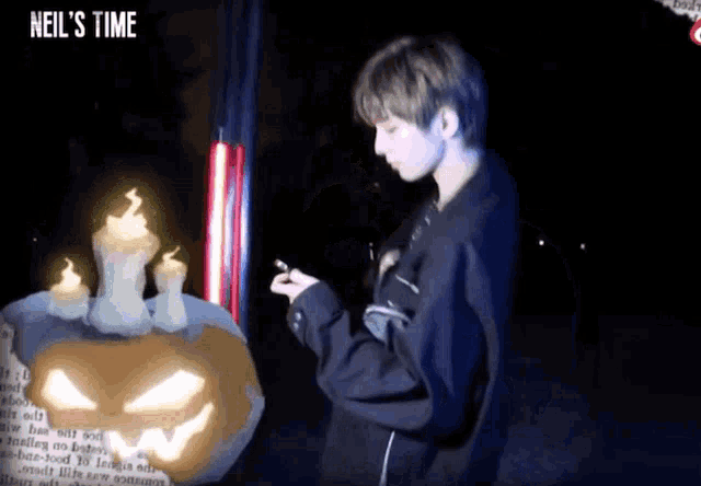 a man standing next to a pumpkin with candles on it and the words neil 's time