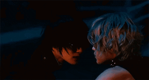 a man and a woman are sitting next to each other in a dark room .
