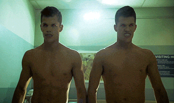 two shirtless men standing next to each other in front of a sign that says visiting hospital