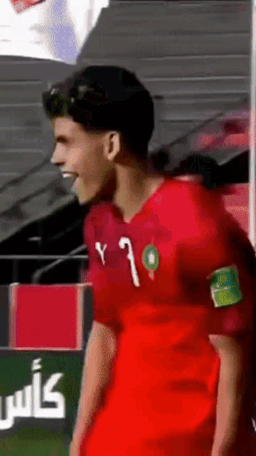 a soccer player wearing a red jersey with the number 7 on it