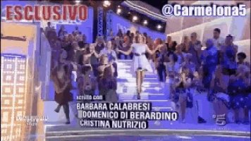 a woman in a white dress is dancing in front of a crowd with the words esclusivo on the top left