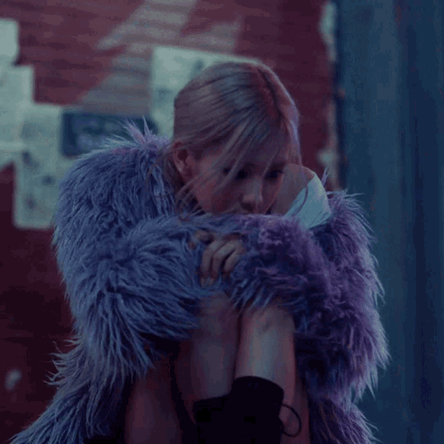 a woman is wearing a purple fur coat