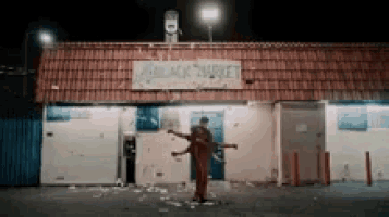 a person is standing in front of a building with a sign that says black market .