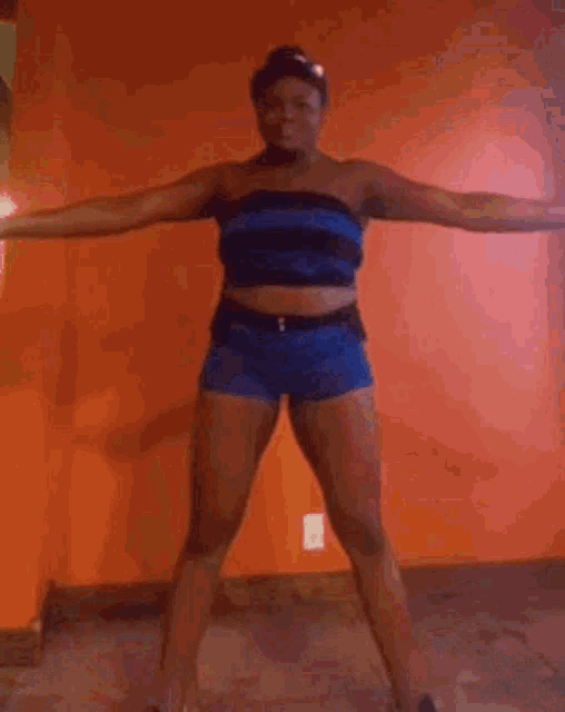 a woman in blue shorts and a blue top is dancing