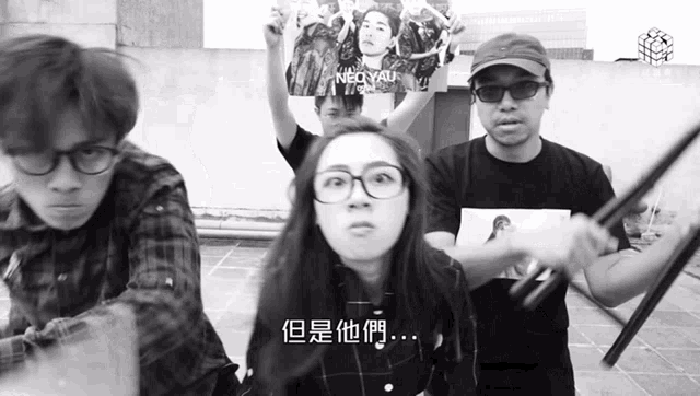 a black and white photo of a group of people holding up a poster that says neo yau