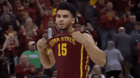 a basketball player for iowa state is giving a thumbs up in front of a crowd .