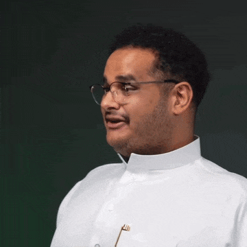 a man wearing glasses and a white shirt is talking .