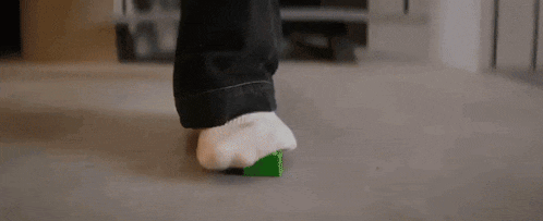 a man is dancing in a living room next to stairs .