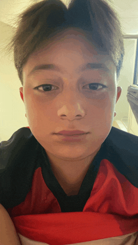 a close up of a person 's face with a red and black shirt