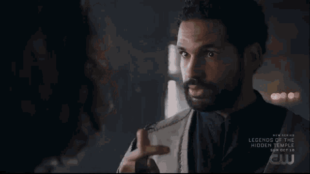 a man with long hair and a beard is talking to another man