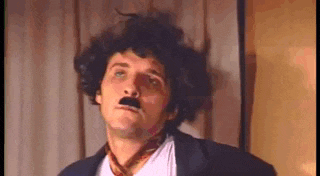 a man wearing a wig and a mustache is making a funny face .