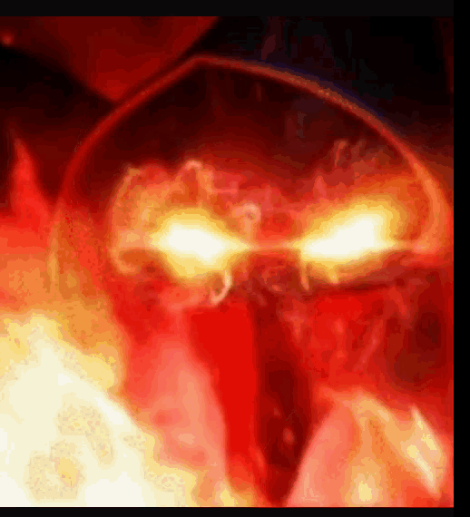 a close up of a demon 's face with flames coming out of its eyes .