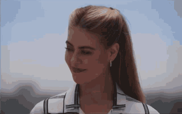 a woman with her hair in a ponytail and earrings