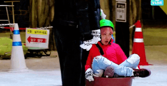 a person wearing a green helmet is sitting on a sled with a sign that says vlive on the bottom