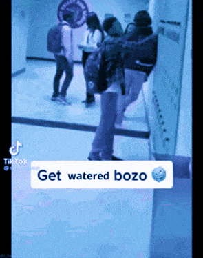 a group of people standing in a hallway with a caption that says " get watered bozo "