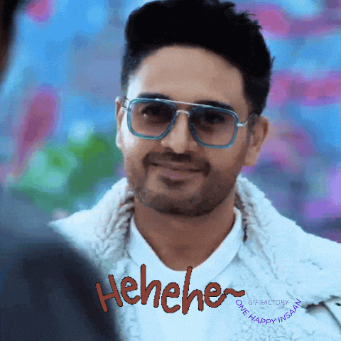 a man wearing sunglasses and a white jacket is laughing with the word ' henehe ' on the bottom right