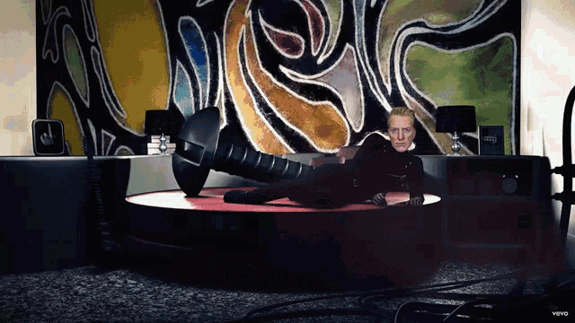 a video of a man laying on a stage with the word vevo on the bottom right corner