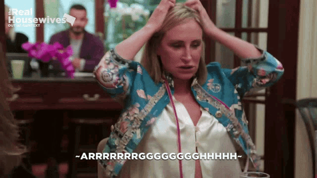 a woman with her hands on her head is on a real housewives tv show