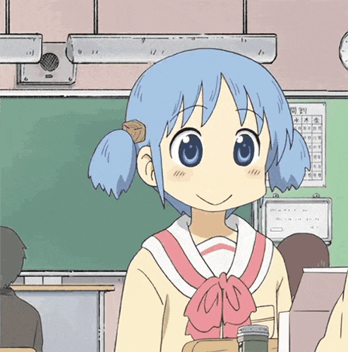 a girl with blue hair is smiling in a classroom with a calendar behind her