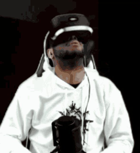 a man wearing a virtual reality headset is holding a cup