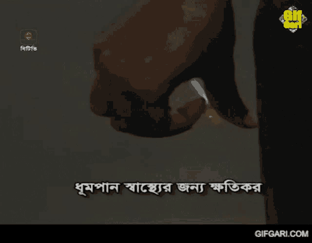 a person is holding a cigarette in front of a screen that says gif gari
