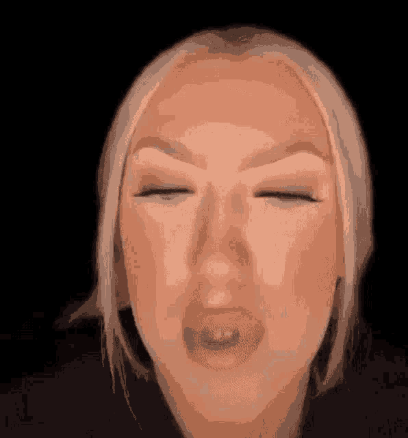 a close up of a woman 's face with her eyes closed and her mouth open .
