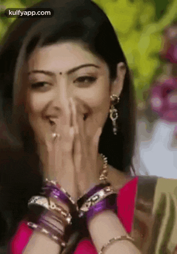 a close up of a woman covering her mouth with her hands .