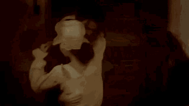 a man is standing next to a tree in a dark room holding a child .