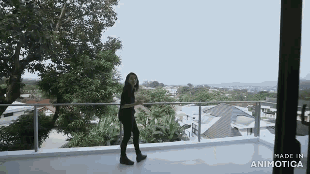 a woman standing on a balcony with the words made in aninotica on the bottom right