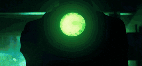a green light is shining in the dark