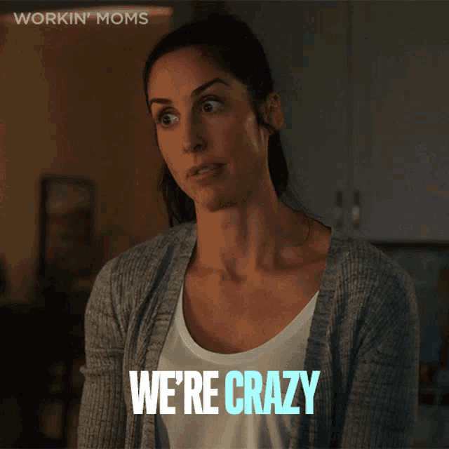 a woman says we 're crazy while wearing a grey cardigan