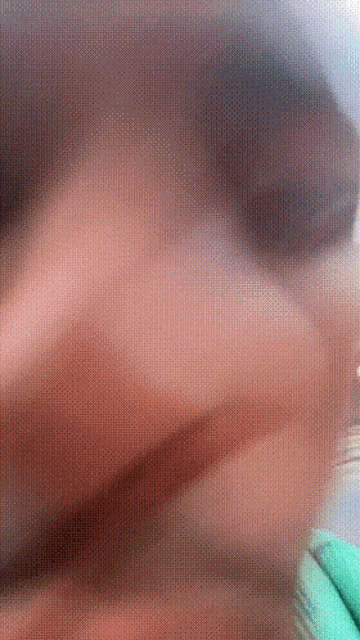 a blurry picture of a person 's face and a green glove