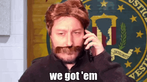 a man with a beard and mustache is talking on a cell phone and says " we got em "