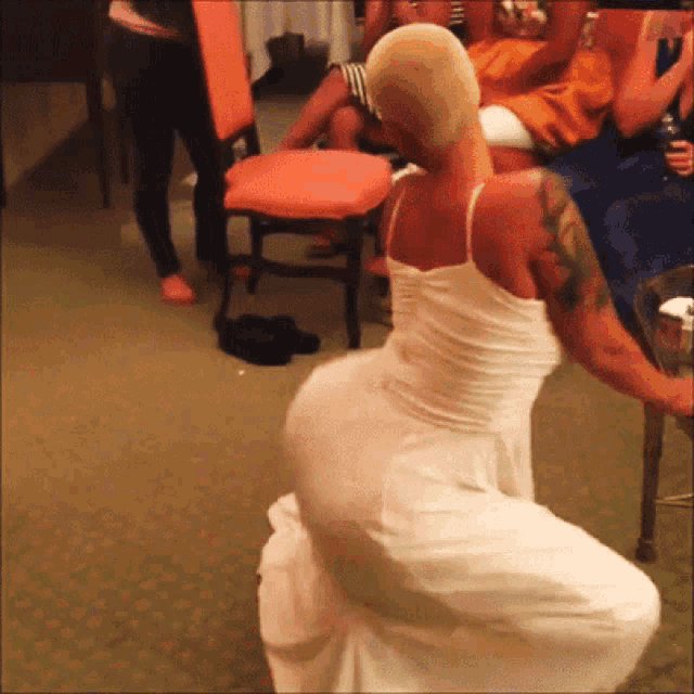 a woman in a white dress with a tattoo on her arm is squatting down