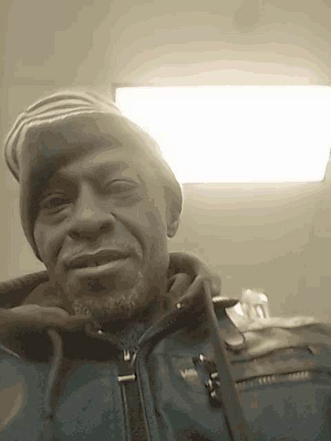 a man wearing a beanie and a jacket with the letter v on the front