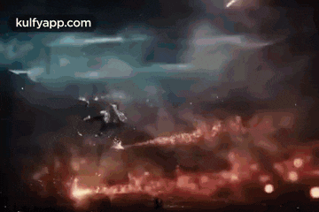 a person is flying through the air in a dark room with fireworks flying in the sky .