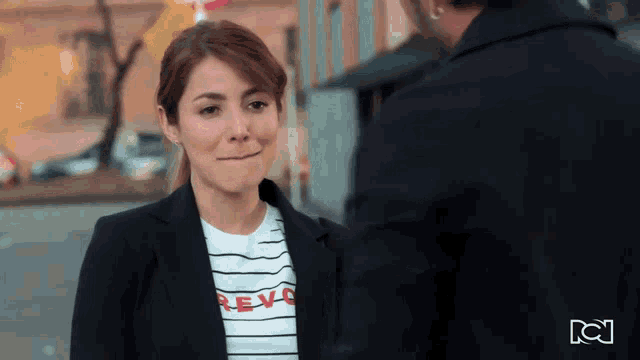 a woman wearing a t-shirt that says revol makes a face