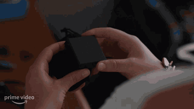 a person is holding a box with an infinity symbol on it and a prime video arrow in the corner