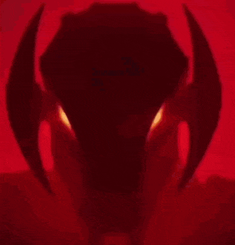a close up of a robot 's head with red eyes .