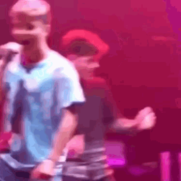 a blurry photo of a man singing into a microphone on a stage