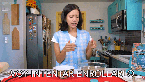 a woman is standing in a kitchen with a bowl of food and the words voy intentar enrollarlo above her