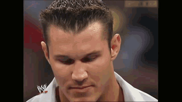 a close up of a wrestler 's face with the letter w on his shirt