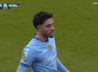 a soccer player in a blue jersey is being hugged by another player during a game .